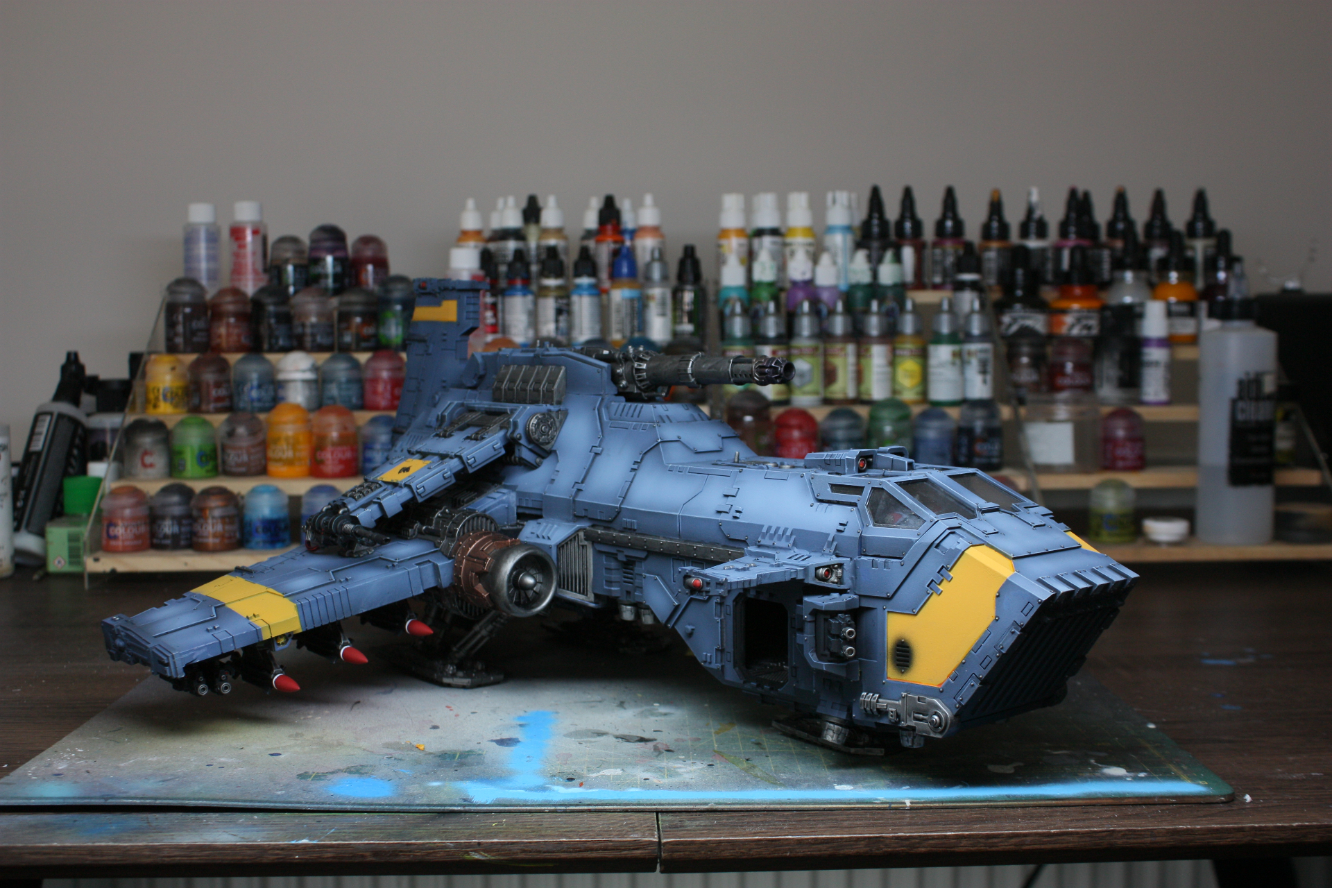 Space Wolves Thunderhawk gunship in grey-blue with yellow panels on workshop table
