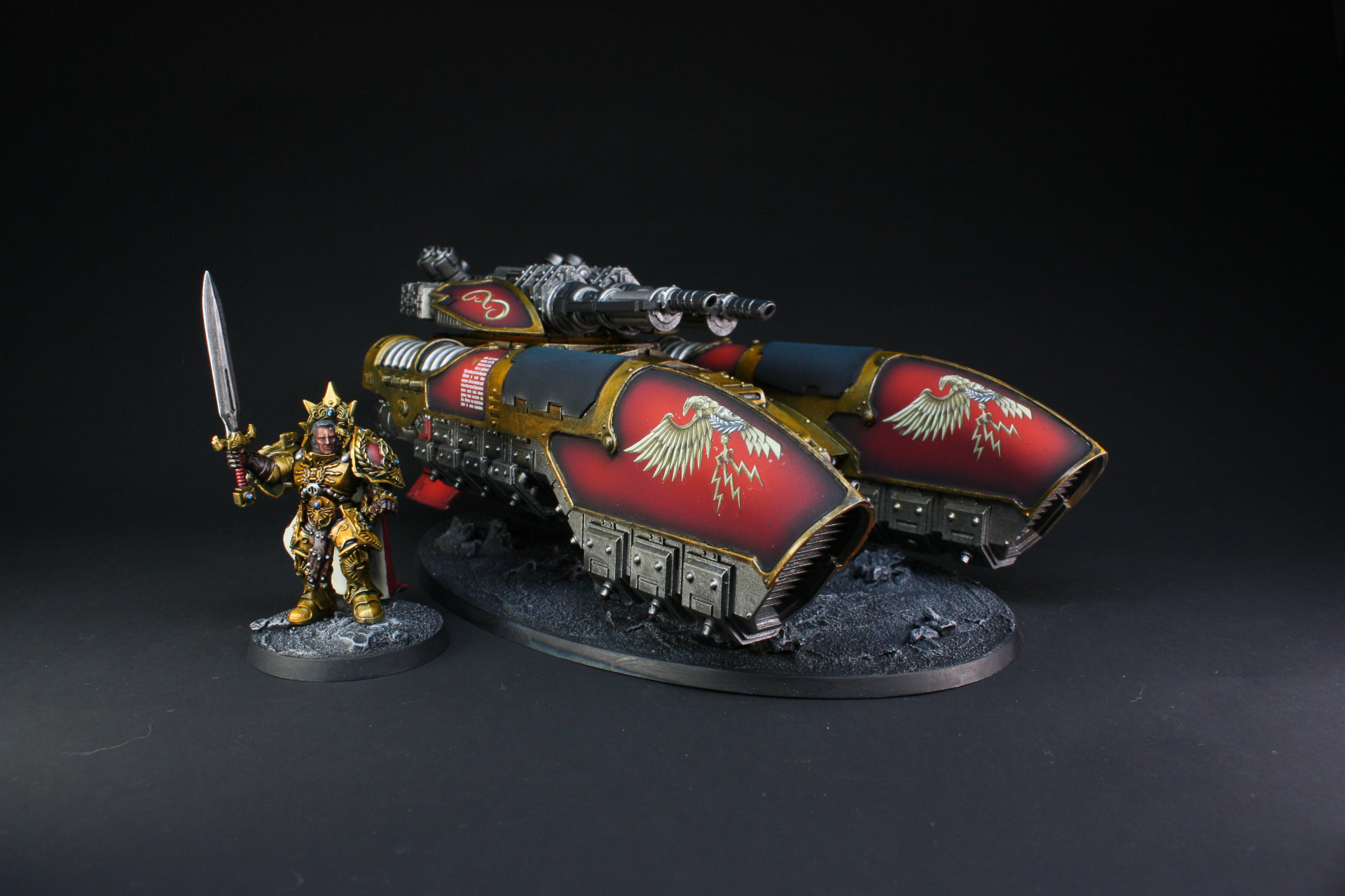 Adeptus Custodes Caladius grav-tank in red and gold beside a Custodian